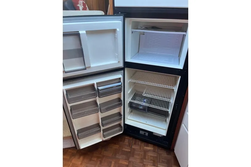 Slide: The Image of Open refrigerator inside 1993 Carver 350 Aft Cabin Motor Yacht, showing shelves and compartments. - 32