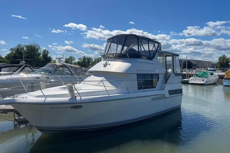 The Image of 1993 Carver 350 Aft Cabin Motor Yacht docked in a marina under blue skies. - 0