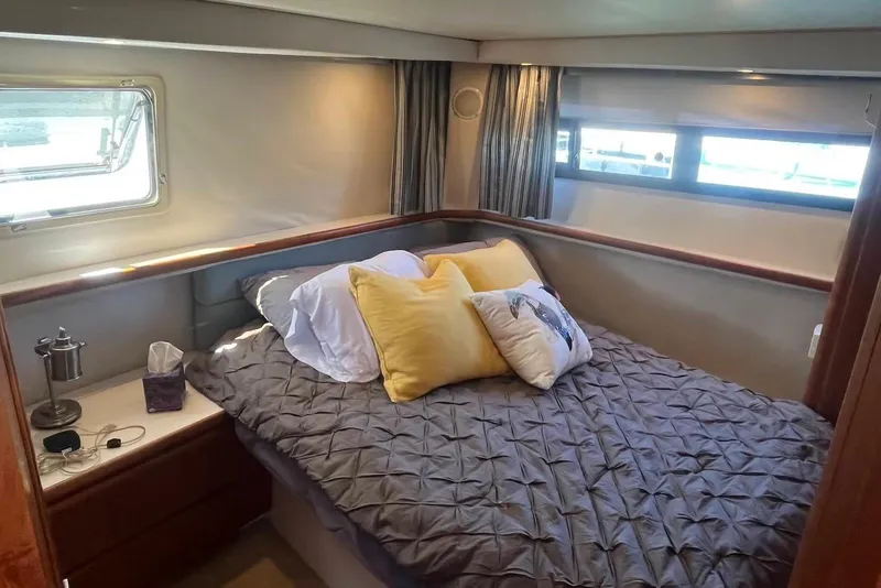 Slide: The Image of Cozy bedroom in 1993 Carver 350 Aft Cabin Motor Yacht with plush bedding and natural light. - 22
