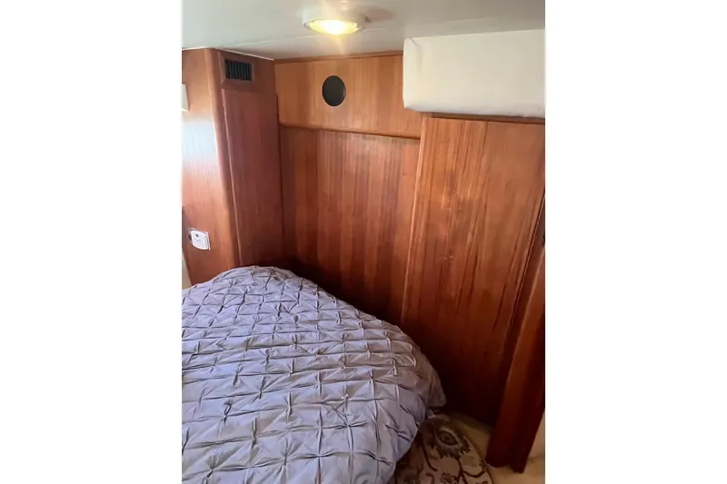 Slide: The Image of 1993 Carver 350 Aft Cabin Motor Yacht interior with wood paneling and cozy bedding. - 23