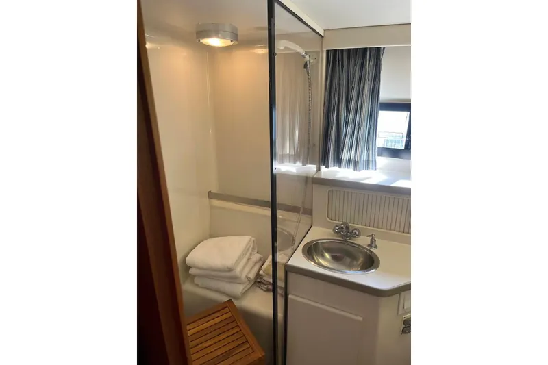 Slide: The Image of 1993 Carver 350 Aft Cabin Motor Yacht bathroom with shower, sink, and towels. - 26