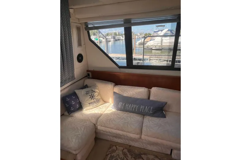Slide: The Image of Interior of 1993 Carver 350 Aft Cabin Yacht with cozy seating and nautical pillows. - 28