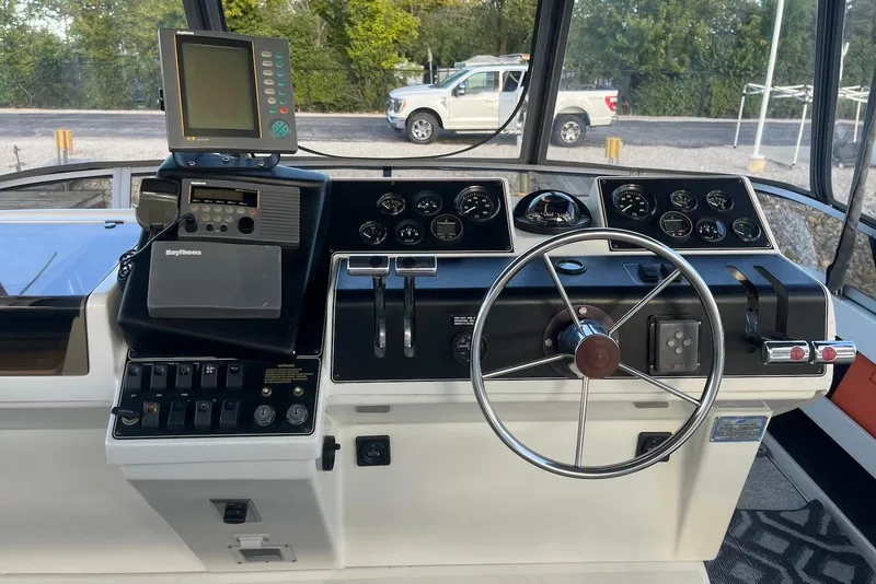 Slide: The Image of 1993 Carver 350 Aft Cabin Motor Yacht helm with steering wheel and navigation equipment. - 6