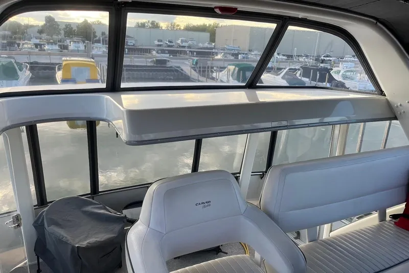 Slide: The Image of 1993 Carver 350 Aft Cabin Motor Yacht interior with white seating and marina view. - 8