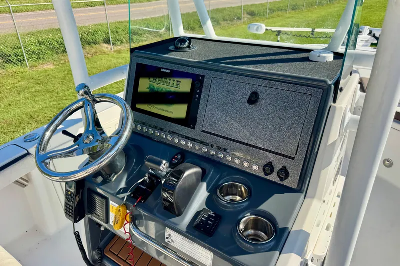 Slide: The Image of 2017 Crevalle 26 Bay boat dashboard with steering wheel and control panel. - 12