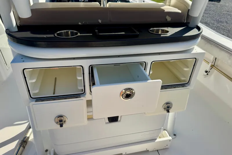 Slide: The Image of 2017 Crevalle 26 Bay boat storage compartments with cup holders and seating. - 18