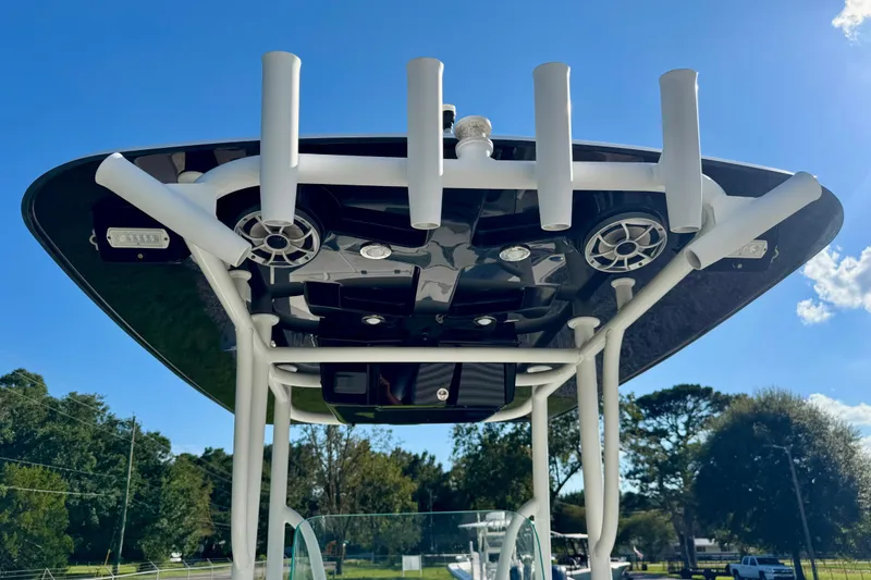 Slide: The Image of 2017 Crevalle 26 Bay boat T-top with rod holders and speakers under clear sky. - 20