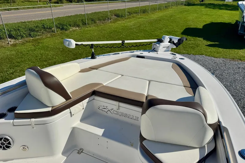 Slide: The Image of 2017 Crevalle 26 Bay boat with cushioned seating and trolling motor on grassy area. - 6