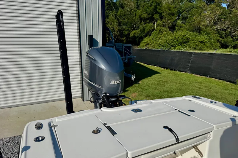 Slide: The Image of 2017 Crevalle 26 Bay boat with Yamaha 300 engine, parked near a metal building. - 9