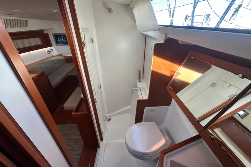 Slide: The Image of Interior of 2014 Beneteau Oceanis 41 yacht, featuring a compact bathroom and seating area. - 14