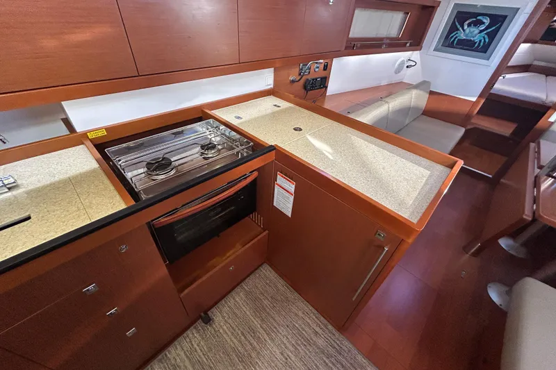 Slide: The Image of 2014 Beneteau Oceanis 41 yacht interior kitchen with stove, oven, and seating area. - 22