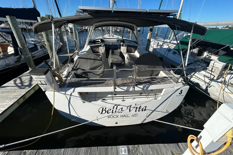 Slide: The Image of 2014 Beneteau Oceanis 41 sailboat docked, rear view with "Bella Vita" name visible. - 37