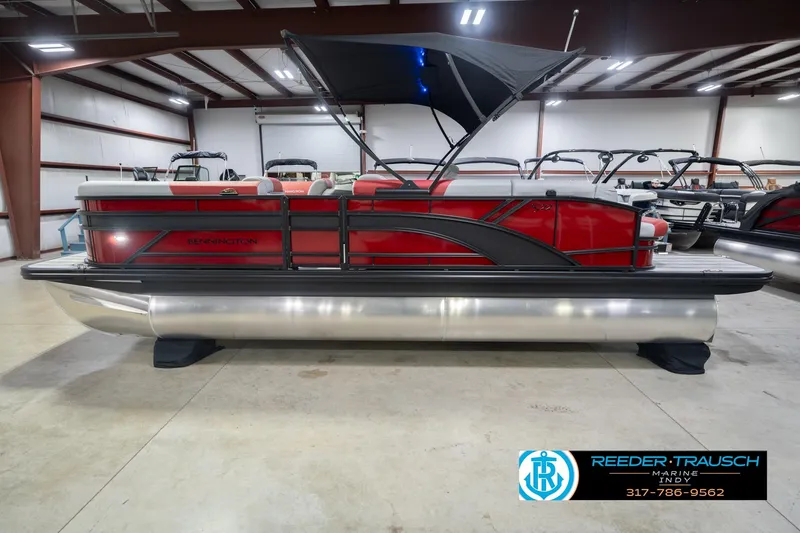Slide: The Image of 2026 Bennington 22 SLJ pontoon boat in showroom with red and black design. - 11