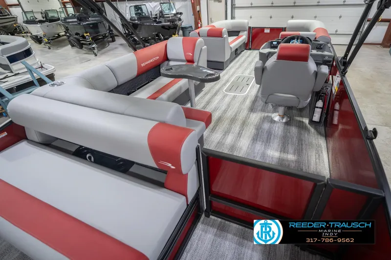 Slide: The Image of 2026 Bennington 22 SLJ pontoon boat interior with red and gray seating, showcased indoors. - 14