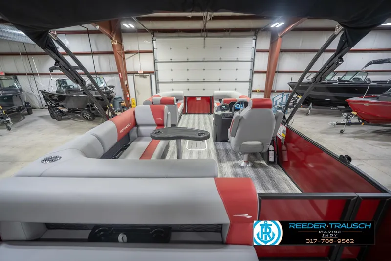 Slide: The Image of 2026 Bennington 22 SLJ pontoon boat interior with red and gray seating in a showroom. - 19