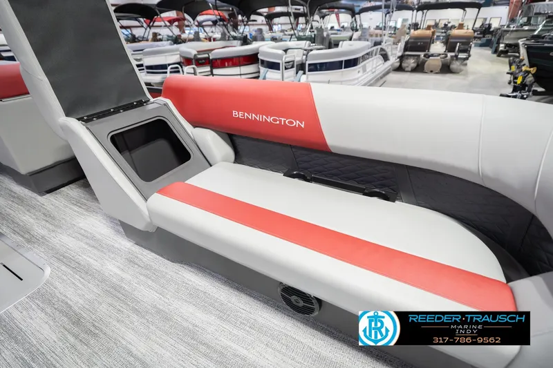Slide: The Image of 2026 Bennington 22 SLJ boat interior with red and gray seating, showcased at a marine dealership. - 23