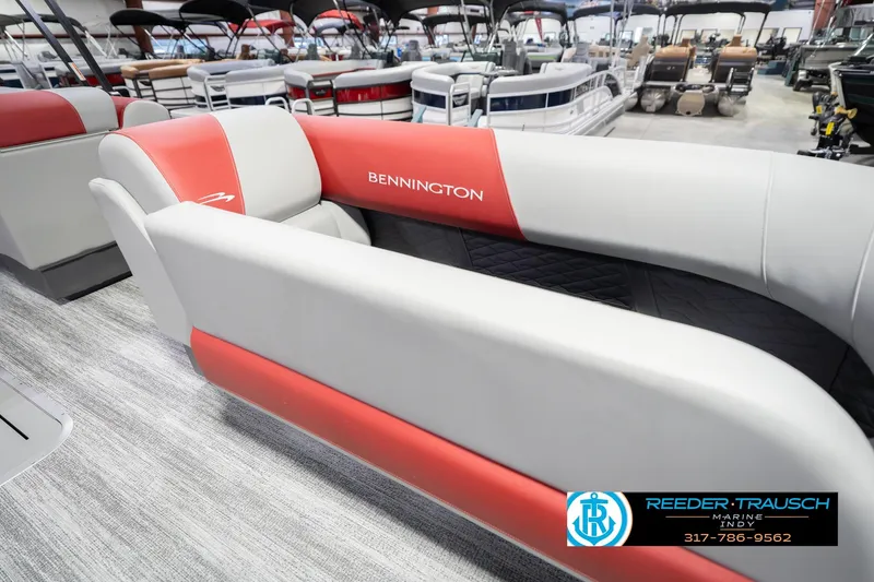 Slide: The Image of 2026 Bennington 22 SLJ boat interior with red and gray seating at Reeder-Trausch Marine showroom. - 24
