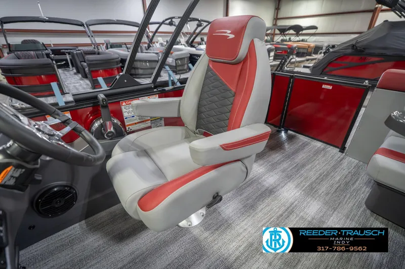 Slide: The Image of 2026 Bennington 22 SLJ boat interior with red and gray captain's chair, showroom display. - 26