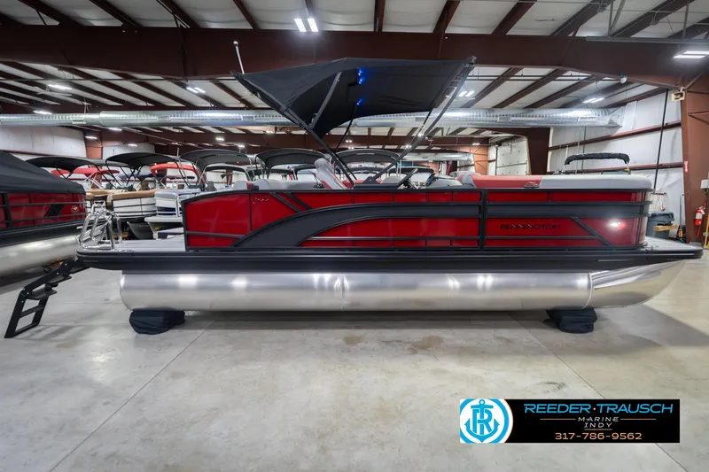 Slide: The Image of 2026 Bennington 22 SLJ pontoon boat in showroom, featuring sleek red and black design. - 7