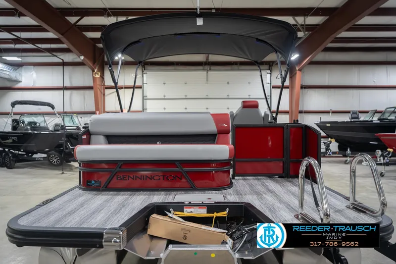 Slide: The Image of 2026 Bennington 22 SLJ pontoon boat in showroom, featuring sleek design and modern seating. - 9