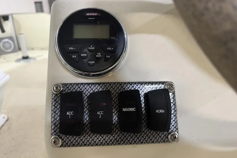 Slide: The Image of Control panel of 2022 Fiesta 16 Fish N Fun boat with switches and Jensen stereo. - 10