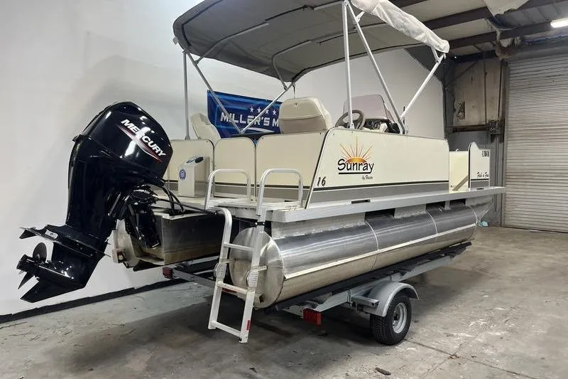Slide: The Image of 2022 Fiesta 16 Fish N Fun pontoon boat with Mercury outboard motor in a garage. - 3