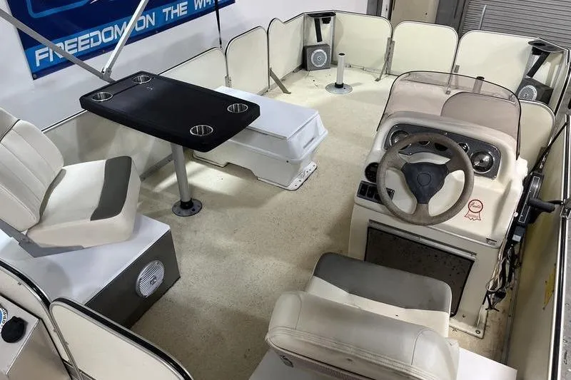 Slide: The Image of 2022 Fiesta 16 Fish N Fun boat interior with seating, table, and steering console. - 6