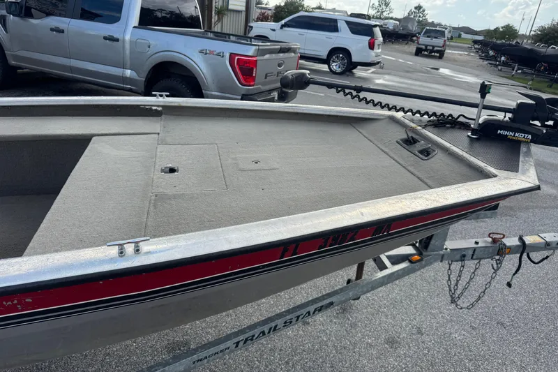 Slide: The Image of 2020 Tracker boat on trailer with Minn Kota motor, parked near trucks. - 3