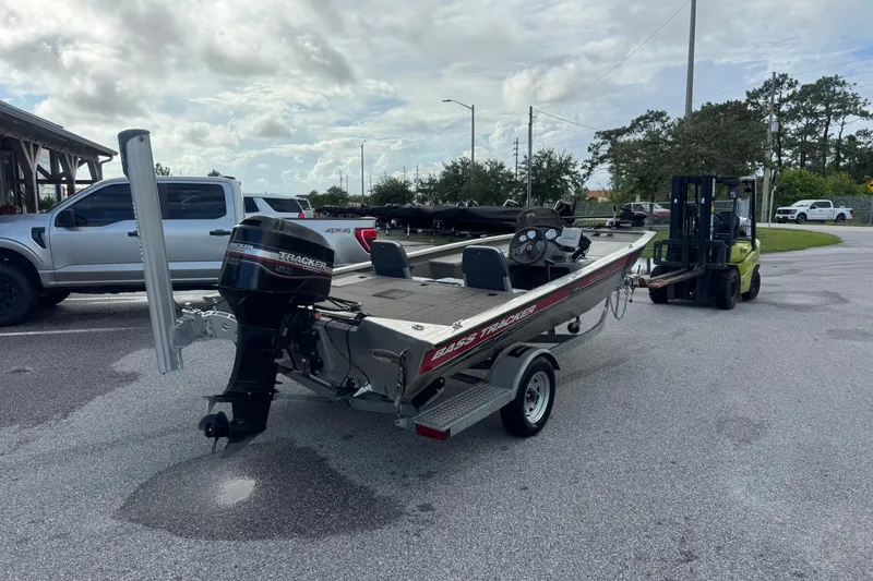 Slide: The Image of 2020 Tracker boat on trailer, parked near a pickup truck and forklift in a lot. - 5