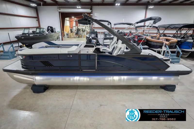 The Image of 2026 Bennington 24 MCSB pontoon boat in showroom, side view, with sleek design and seating. - 0