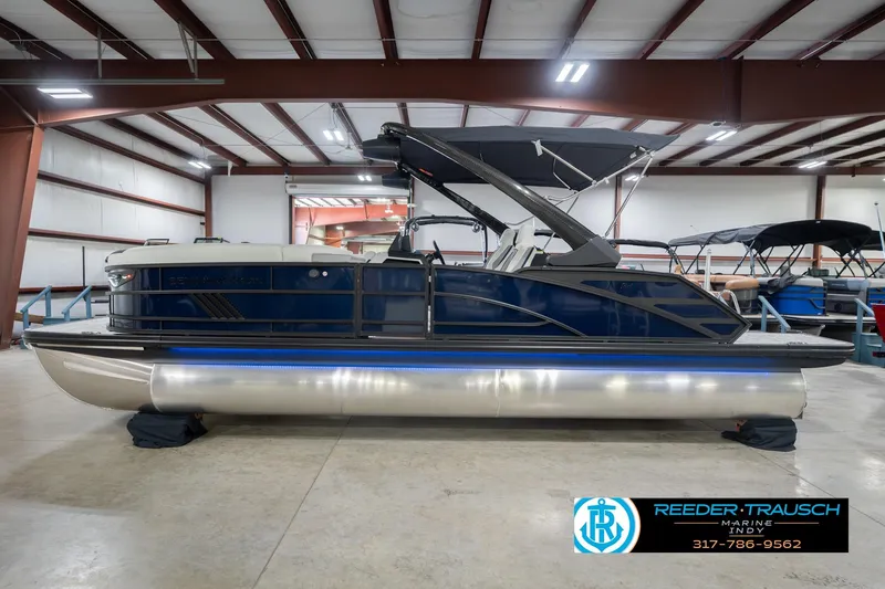 Slide: The Image of 2026 Bennington 24 MCSB pontoon boat in showroom, featuring sleek design and modern amenities. - 11