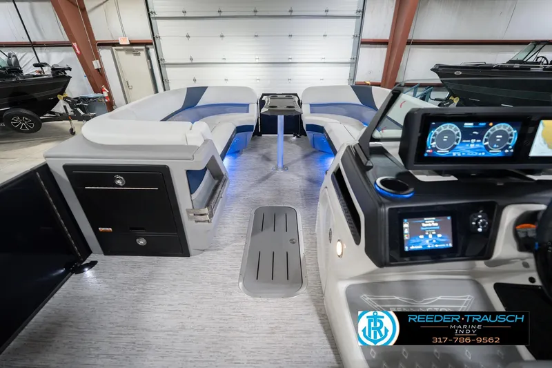 Slide: The Image of 2026 Bennington 24 MCSB boat interior with modern dashboard and seating in a showroom. - 20