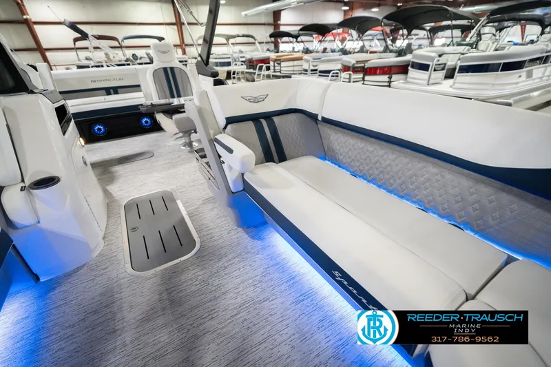 Slide: The Image of 2026 Bennington 24 MCSB boat interior with blue LED lighting and luxurious seating. - 24