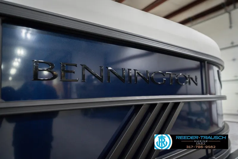 Slide: The Image of 2026 Bennington 24 MCSB boat, close-up of logo, blue and silver design. - 57