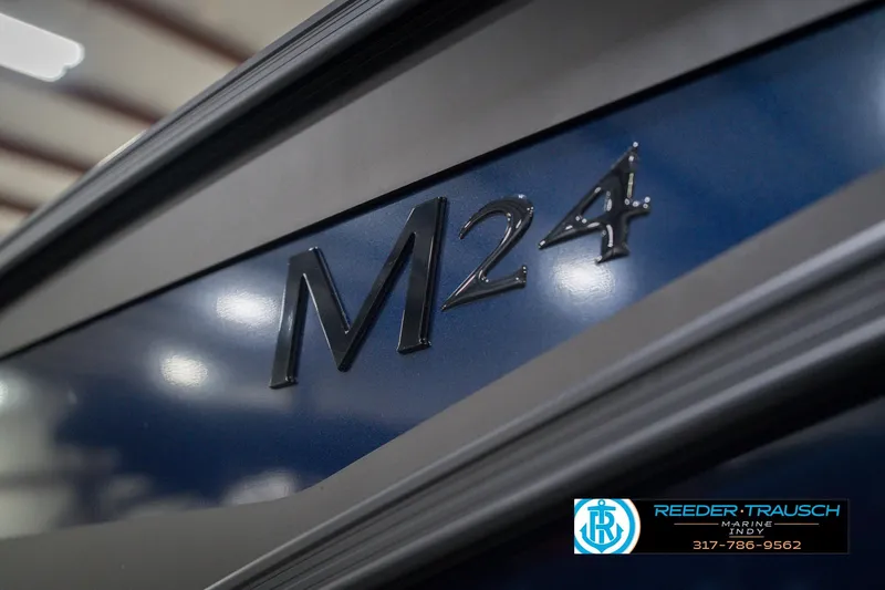 Slide: The Image of 2026 Bennington 24 MCSB boat with M24 emblem, showcased at Reeder-Trausch Marine. - 58