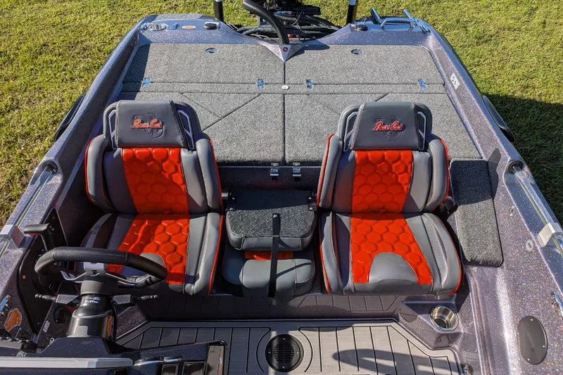 Slide: The Image of 2026 Bass Cat Eyra SP boat interior with red and gray seats, steering wheel, and deck. - 13