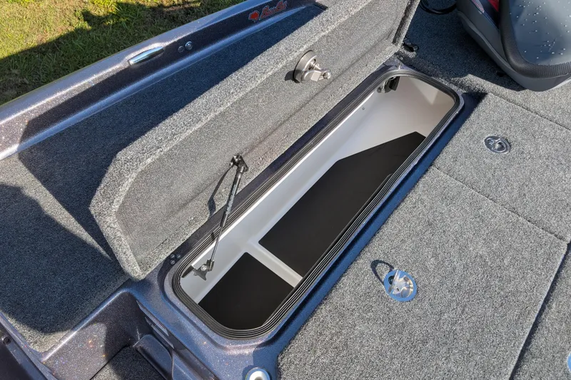 Slide: The Image of 2026 Bass Cat Eyra SP boat storage compartment with open lid, showcasing interior space. - 17