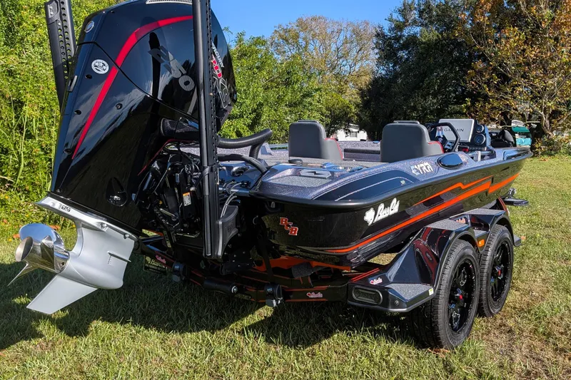 Slide: The Image of 2026 Bass Cat Eyra SP boat with powerful engine, parked on grass, showcasing sleek design. - 6