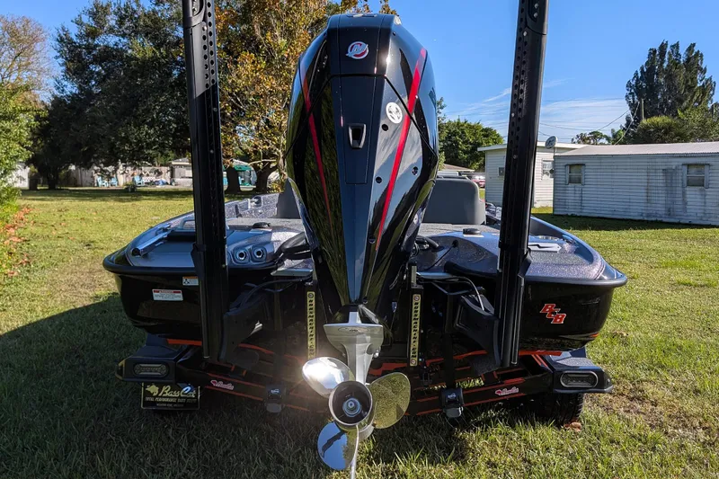 Slide: The Image of 2026 Bass Cat Eyra SP boat with powerful outboard motor, parked on grass. - 7