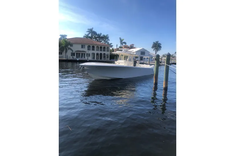 Slide: The Image of 2019 SeaVee 370z boat docked by waterfront homes, under clear blue sky. - 3