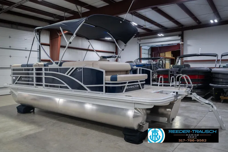 Slide: The Image of 2026 Bennington 21 SLJ pontoon boat in showroom, featuring sleek design and canopy. - 10