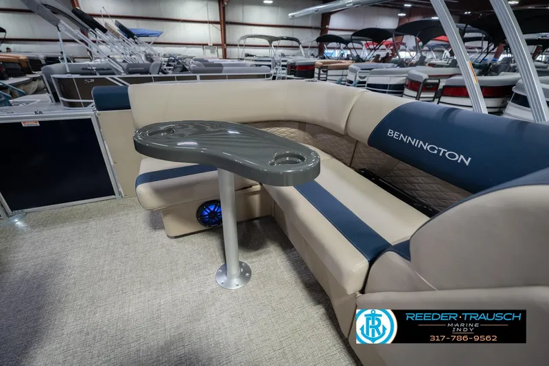 Slide: The Image of 2026 Bennington 21 SLJ pontoon boat interior with seating and table in showroom. - 23