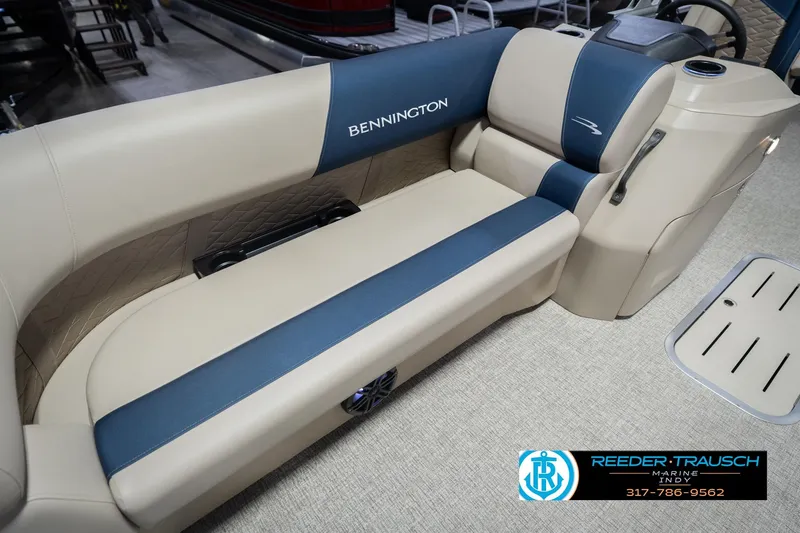 Slide: The Image of 2026 Bennington 21 SLJ boat interior with beige and blue seating, Reeder-Trausch Marine logo. - 40