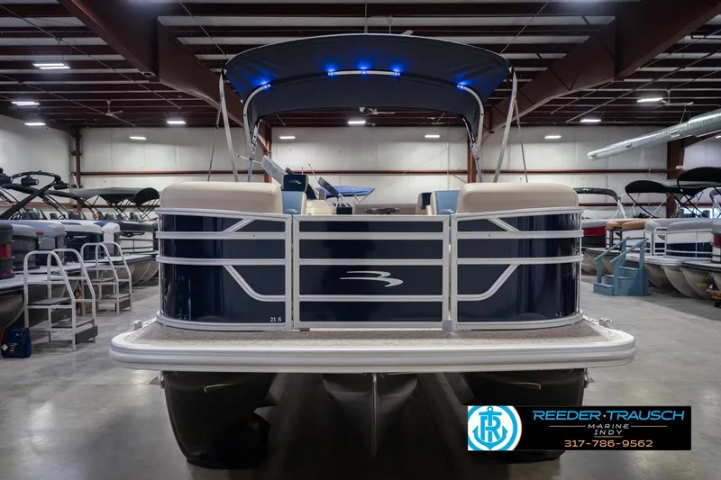 Slide: The Image of 2026 Bennington 21 SLJ pontoon boat in showroom, featuring sleek design and blue accents. - 5