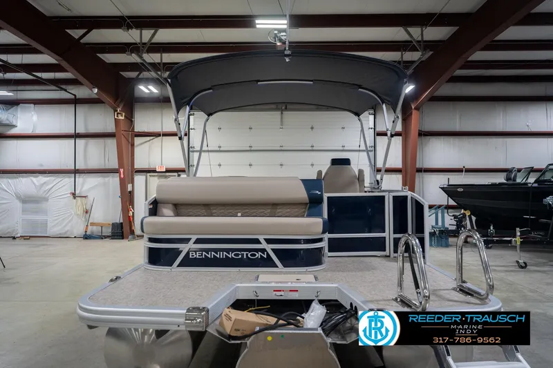 Slide: The Image of 2026 Bennington 21 SLJ pontoon boat in a spacious indoor showroom. - 9