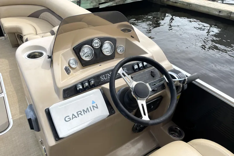 Slide: The Image of 2019 Harris Sunliner 250 boat dashboard with Garmin navigation system and steering wheel. - 13