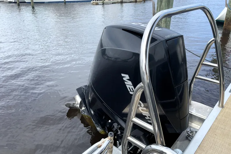 Slide: The Image of 2019 Harris Sunliner 250 with Mercury outboard motor docked by the water. - 20