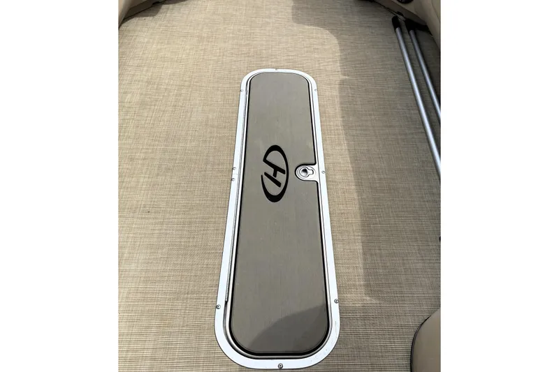 Slide: The Image of 2019 Harris Sunliner 250 boat deck with storage compartment and logo. - 35