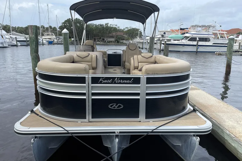 Slide: The Image of 2019 Harris Sunliner 250 pontoon boat docked at marina, featuring beige seating and sleek design. - 4