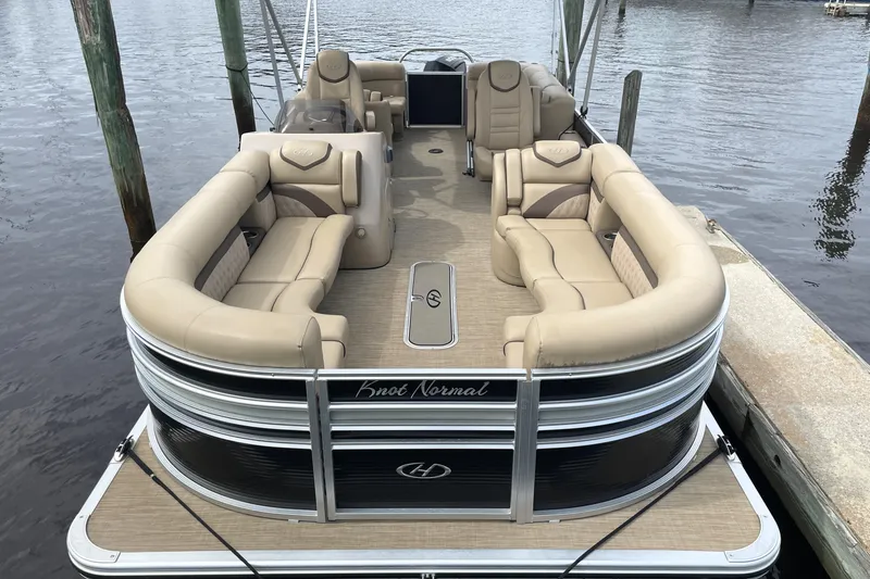 Slide: The Image of 2019 Harris Sunliner 250 pontoon boat with beige seating, docked on calm water. - 5